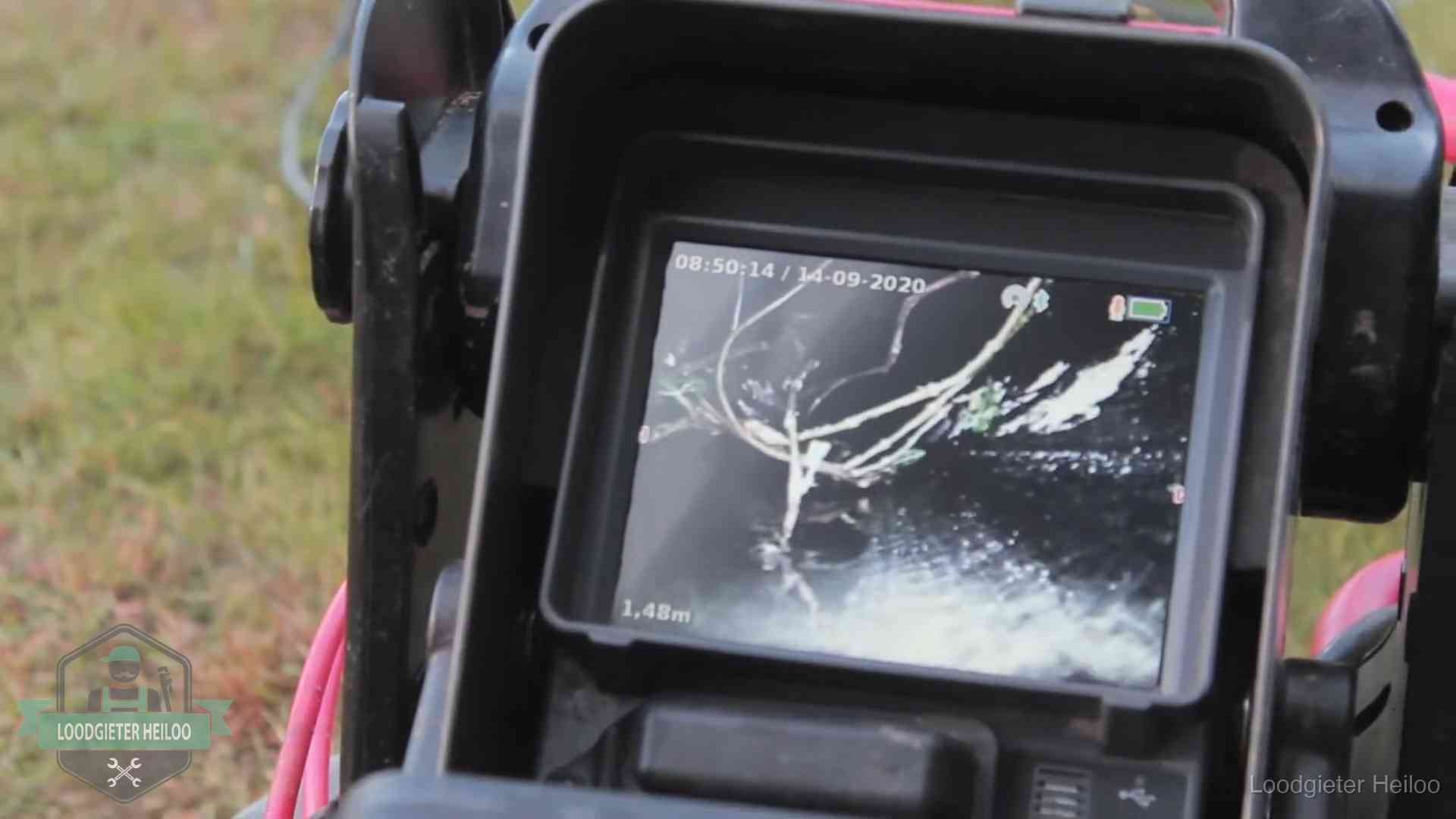 Monitor van een rioolcamera toont wortelingroei in de rioolbuis bij een woning in Heiloo