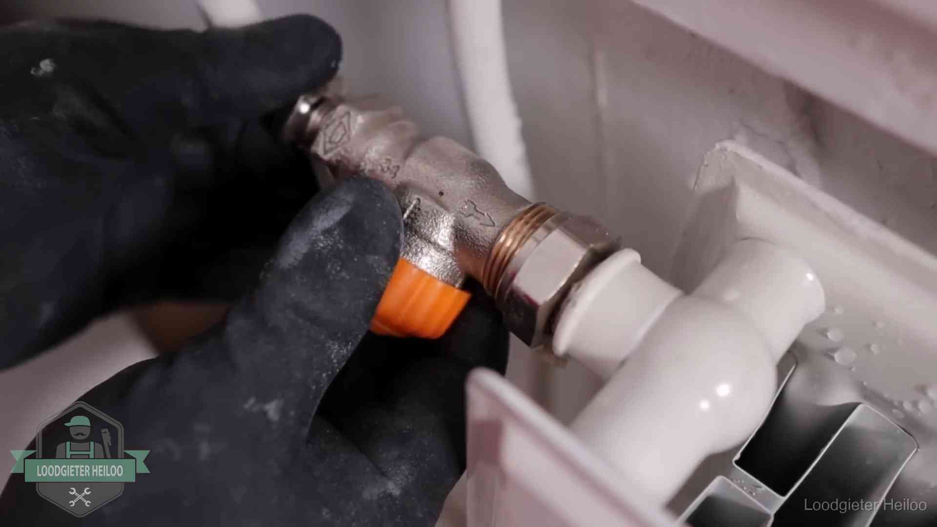 Thermostaatkraan wordt gemonteerd op een radiator in Heiloo voor het stookseizoen