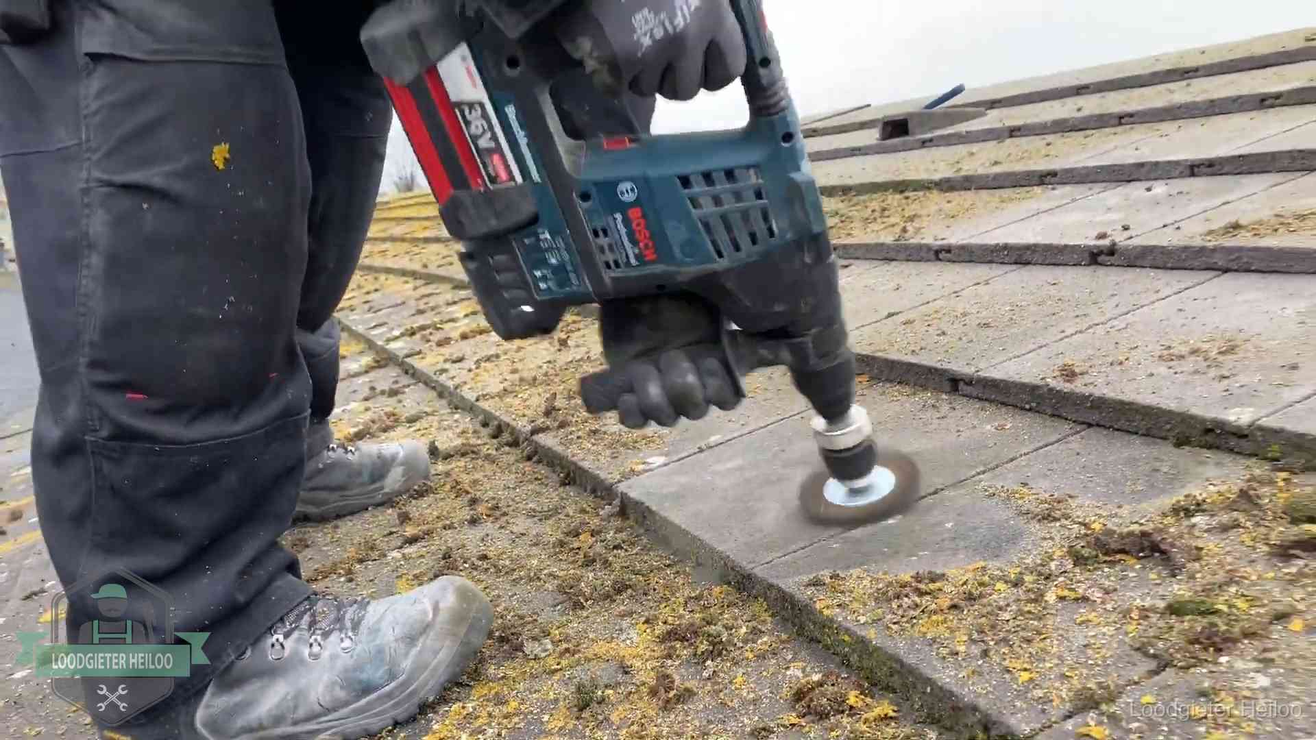 Betonnen dakpannen worden machinaal gereinigd tijdens dakonderhoud in Heiloo
