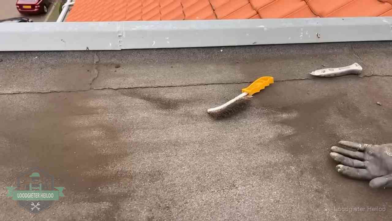 Dakdekker bereidt een bitumen plat dak voor op reparatie bij de daktrim in Heiloo