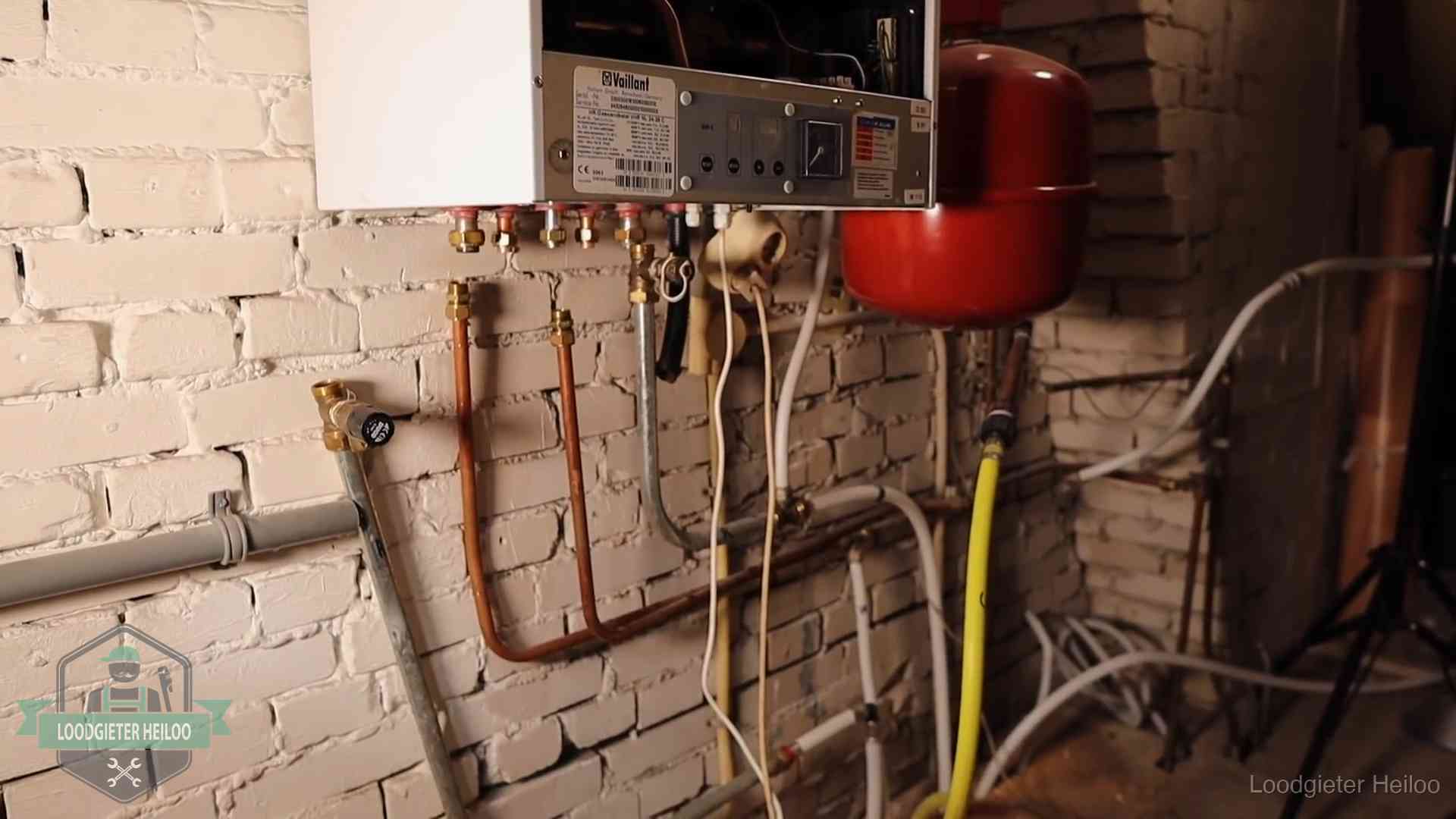Verouderde cv-ketel met een wirwar van oude leidingen in een woning in Heiloo