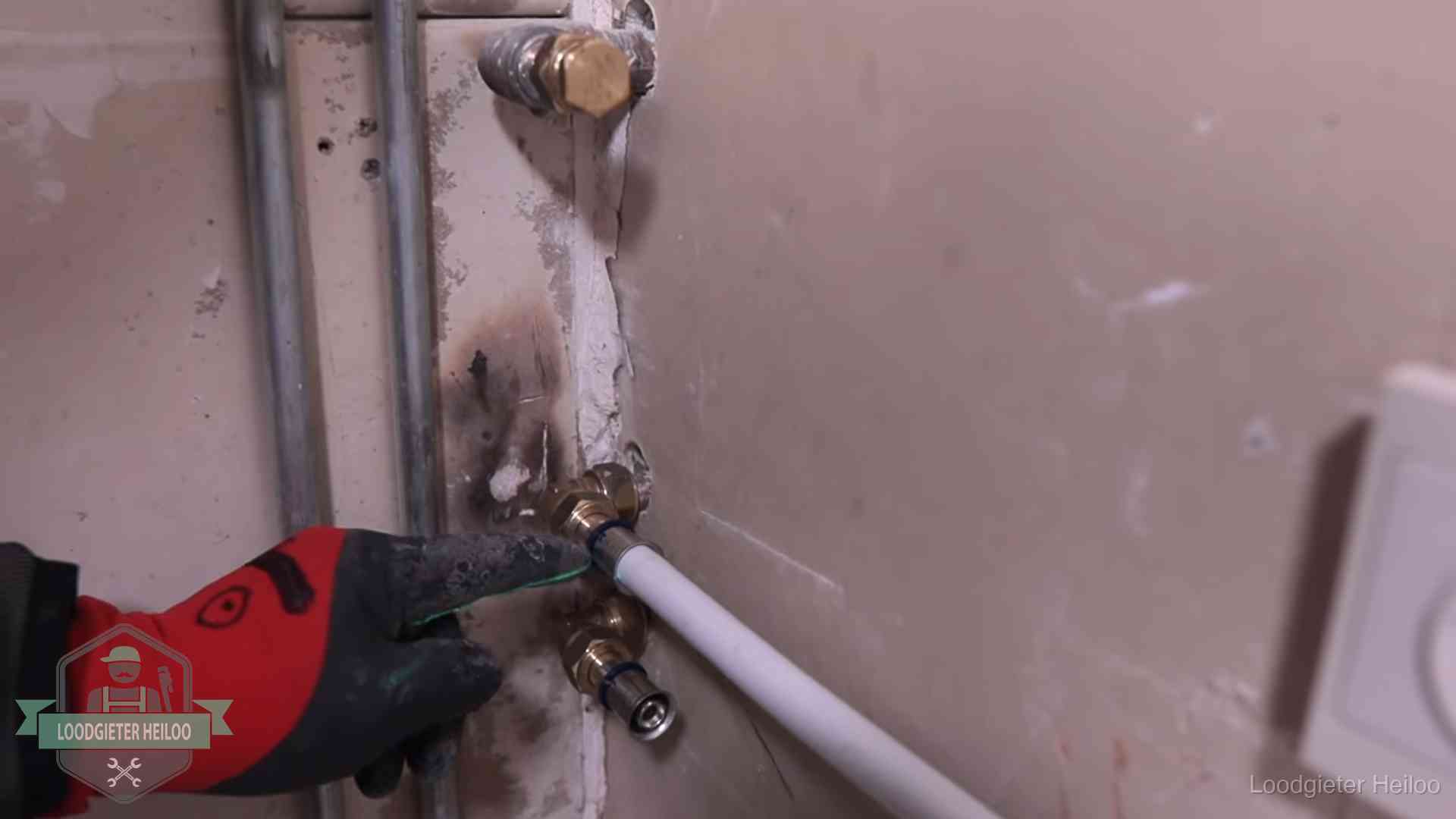 Garantie op loodgieterswerk in Heiloo Loodgieter wijst de persfitting op nieuwe muuraansluitingen aan in een woning in Heiloo