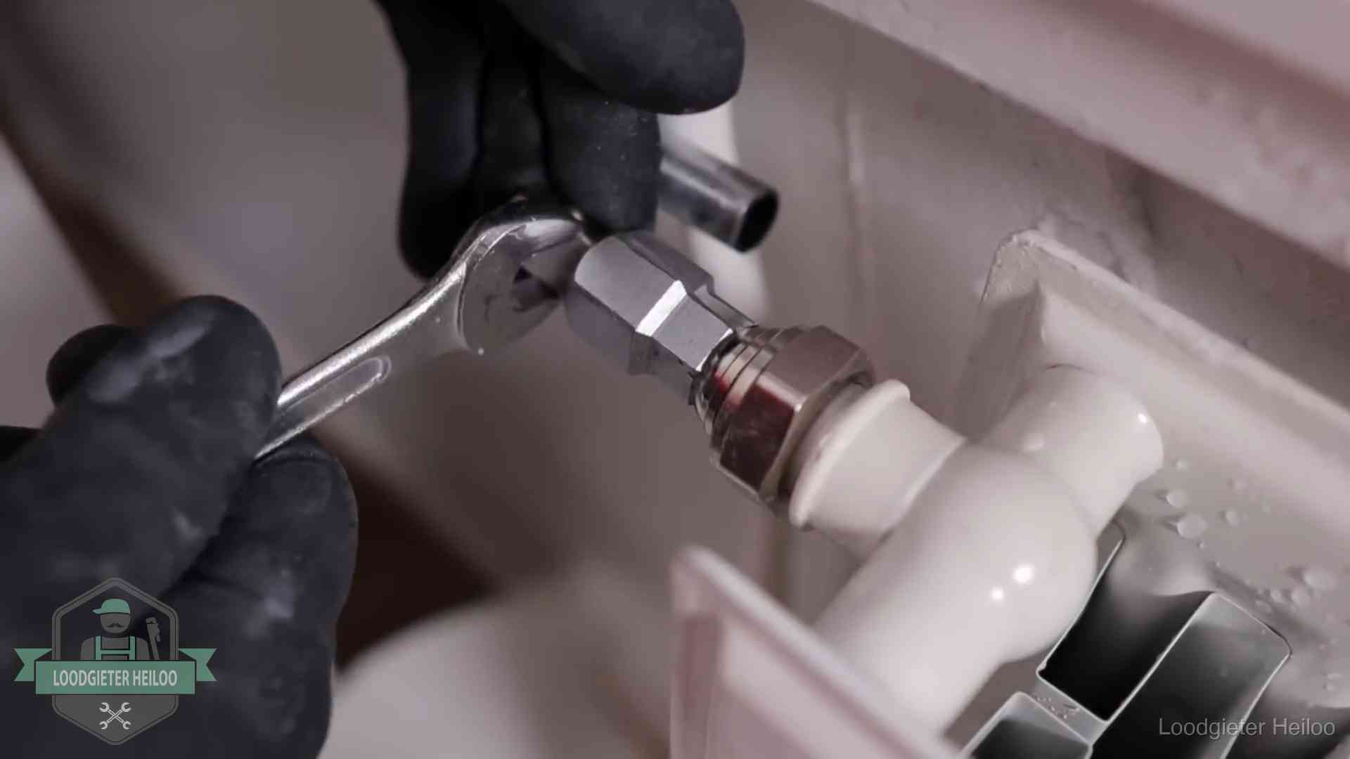 Steeksleutel draait een wartelkoppeling op een radiatorkraan aan in Heiloo