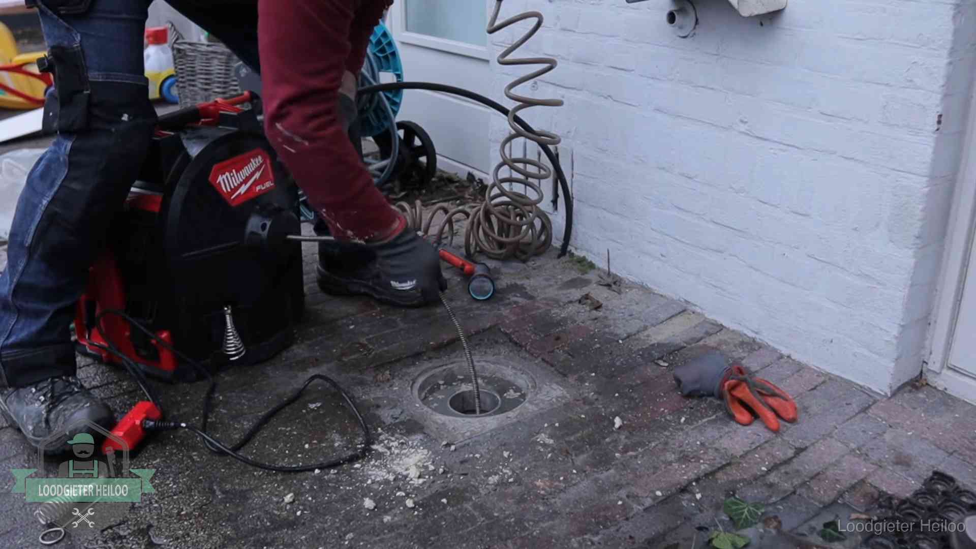 Spiraalmachine bij een ontstoppingsputje in de bestrating in Heiloo