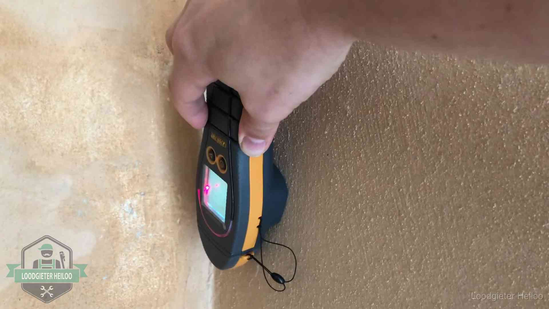 Vochtmeter tegen een muur met vochtplekken tijdens het opsporen van een daklekkage in Heiloo